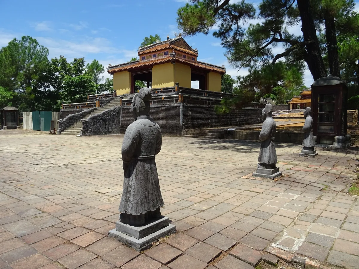 Stone mandarin statues line the courtyard leading to a pavilion at Minh Mang's tomb in Hue.