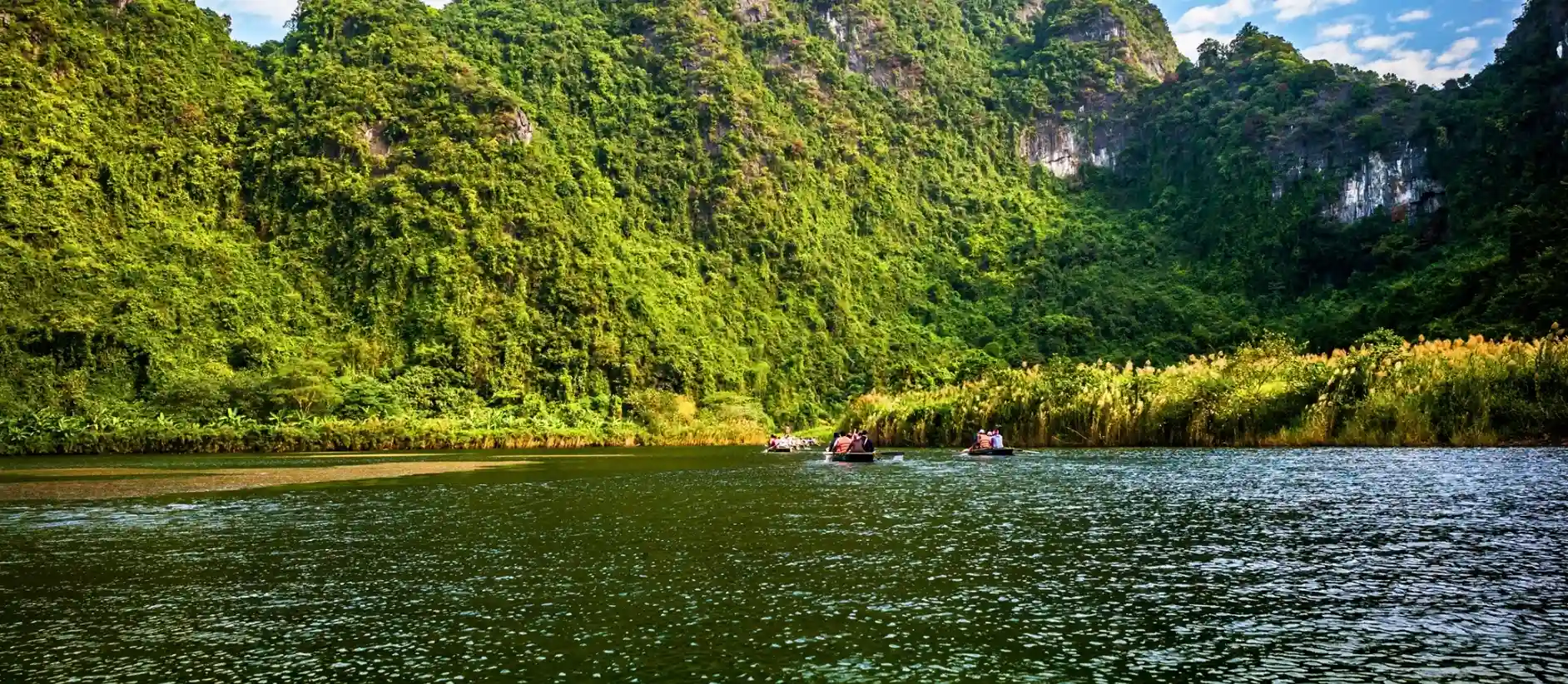 Rowboats on the river between karst peaks at Trang An