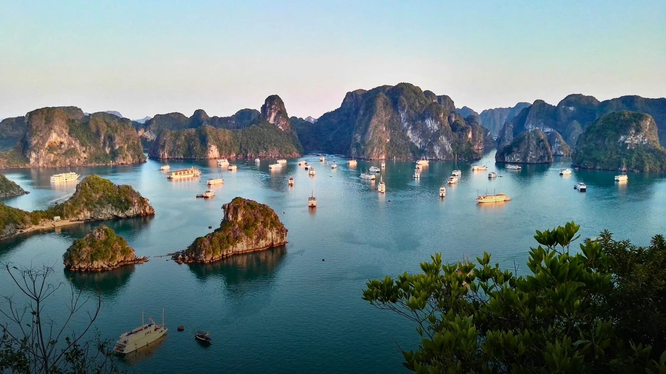 Limestone islands rising from calm water in Ha Long Bay